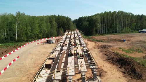 Construction Team in Hard Hats Work at the Construction Site Aerial View