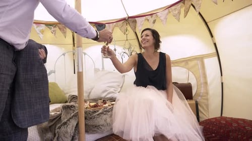 Bride Cheers with Champagne in Decorated Tent