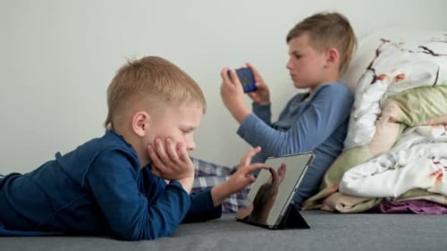 Boys Playing Games on Tablet and Smartphone