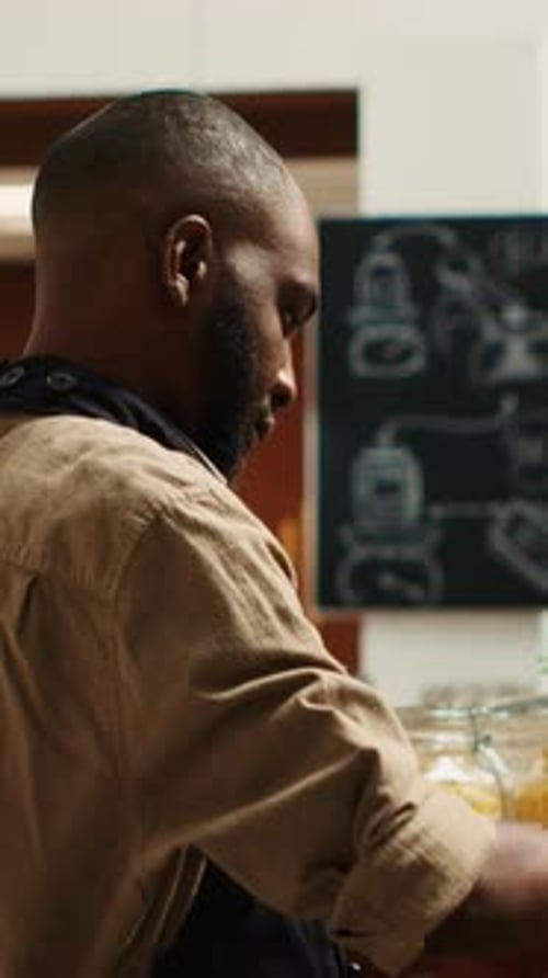 Vertical Video Merchant with Apron Placing Bulk Items on Shelves at Eco Store