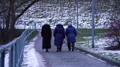 A group of three multi-ethnic senior women exercising outdoors together on a city winter on a gloomy