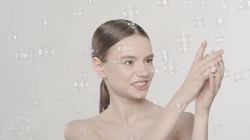 Smiling Woman in Bubble Filled Studio