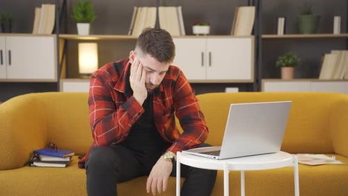 Stressed Adult Closes Laptop on Couch