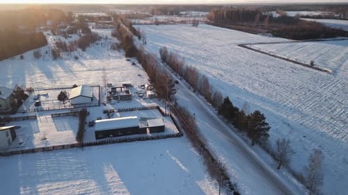 Car Drives Snowy Road in Winter Landscape