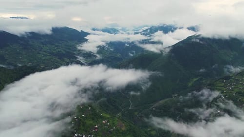 Green Mountain Range Through White Clouds Aerial View