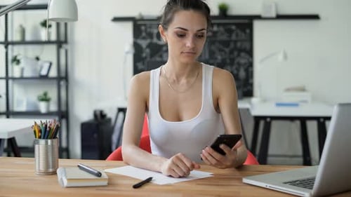 Businesswoman Looking At Cellphone With Green Screen In Workplace. Concept Of Copy Space Advertis...