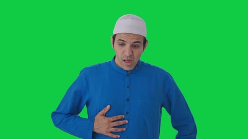 Sick Muslim man suffering from stomach pain Green screen