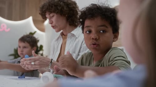 Boy Smiling While Playing with Clay with Others