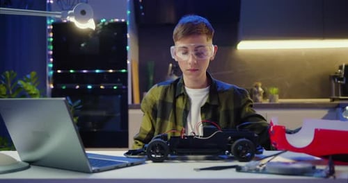 Teen Builds Toy Car with Laptop Assistance