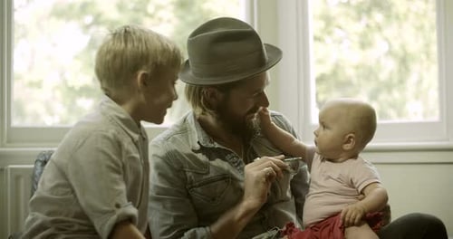 Father and Sons Bonding on Couch at Home