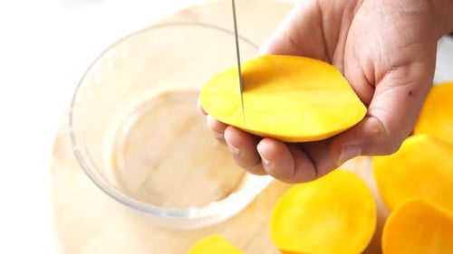 Close Up Of Hands Cutting A Ripe Mango