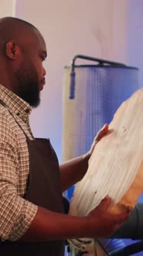 Vertical Video Portrait of Jolly Man Inspecting Wood Piece Evaluating Lumber Block