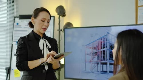 Architects and designers work presenting and discussing house model in office meeting.