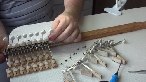 Man Repairing Piano Keys on a Table
