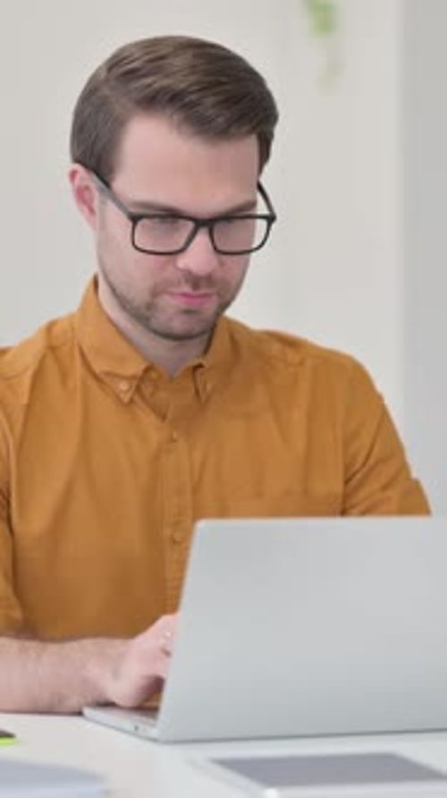 Young Man Working on Laptop in Office, Vertical Video