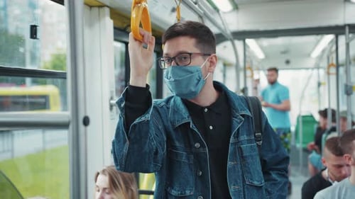 Commuters ride the bus, wear face masks