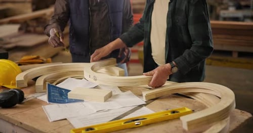 Teamwork, hands or carpenter in workshop with wood, brainstorming and planning on table