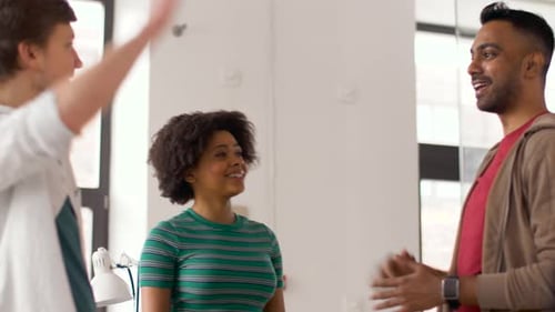 Smiling Colleagues High-Fiving in Modern Workplace