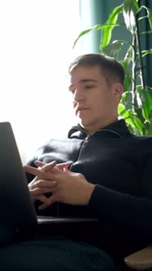 Young Adult Talking to a Laptop Indoors