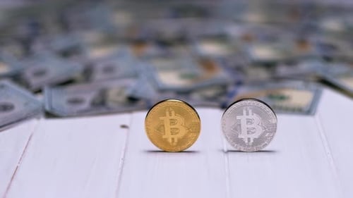 Hand Removes Bitcoins from Money Background