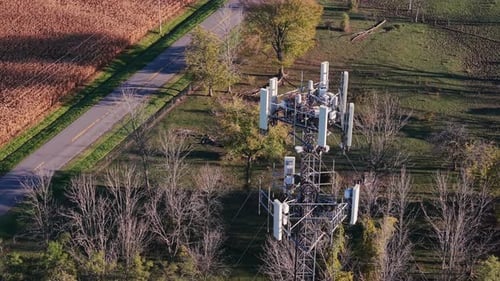 Drone View of a Telecommunication Tower Near a Rural Road Surrounded By Trees and Farmland in Autumn