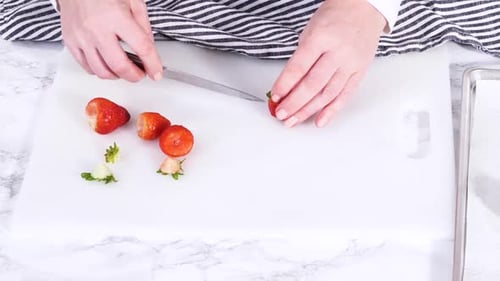 Hands Cutting Fresh Strawberries on a Cutting Board
