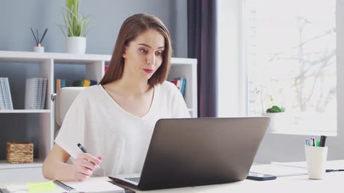 Young Woman Works at Home Office Using Computer She Has a Conference Call Workplace of Female