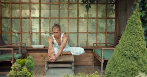 Man Stretching Leg on Wood Porch Outdoors