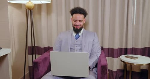 A Successful Businessman is Engaged in Work on His Laptop in a Modern Office Setting