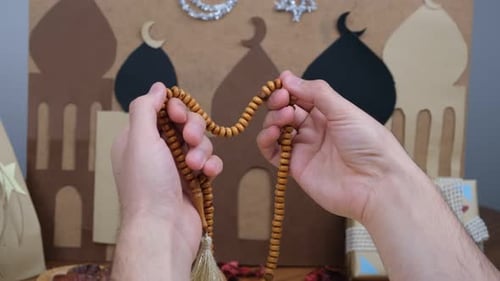 Hands Counting Prayer Beads in a Religious Setting
