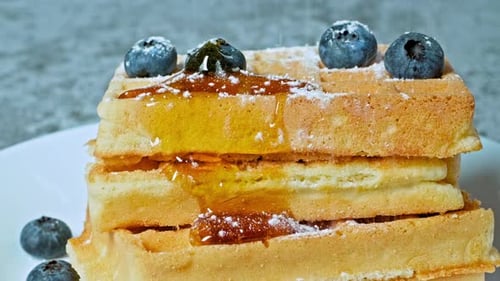 Stack of Waffles Topped with Blueberries and Honey