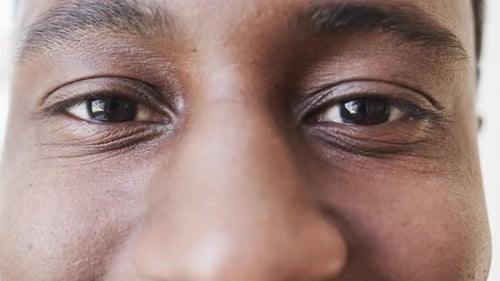 Portrait close up of eyes of happy african american man smiling, in slow motion, copy space