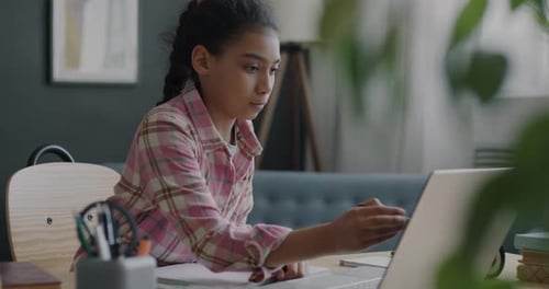 Girl Studies at Desk with Laptop and Notebook
