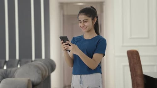 Feliz adolescente india enviando mensajes de texto a alguien