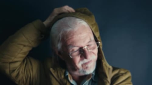 Senior Man Adjusts Hair in Close-Up Studio Portrait