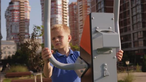 A Small Boy Trains on a Modern Simulator on a Sports Field in the Courtyard