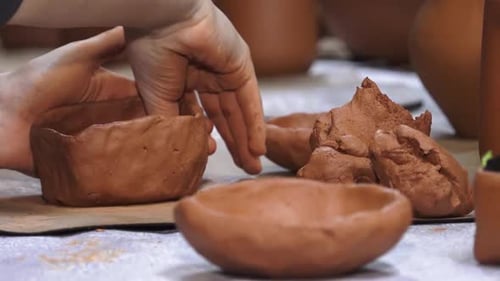 Clay workshop master classes. The hands of children and adults make pottery. Soft selective focus