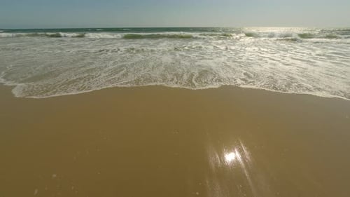 Sandy beach and ocean with waves.