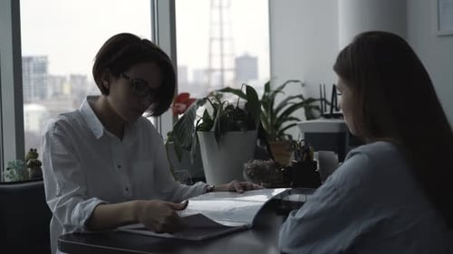 Businesswomen Discussing Contract and Shaking Hands in Office