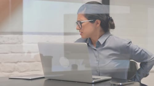 Woman Experiencing Back Pain While Working at Desk