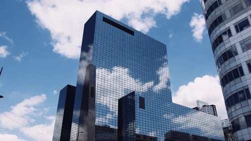 Stunning shot of a large glass skyscraper reflecting the sky in downtown Rotterdam