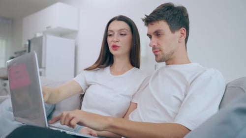 Couple Relaxing at Home Using a Laptop