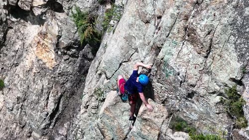 Determined Climber Skillfully Ascending a Steep Rock Face