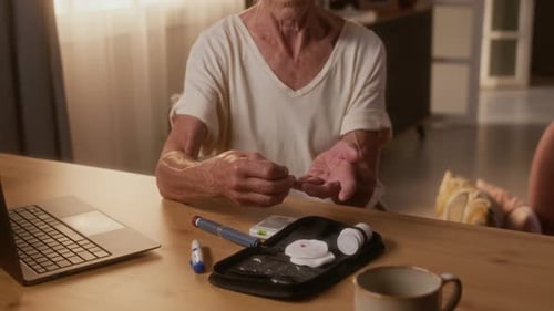 Senior Woman Checks Blood Sugar Level at Home
