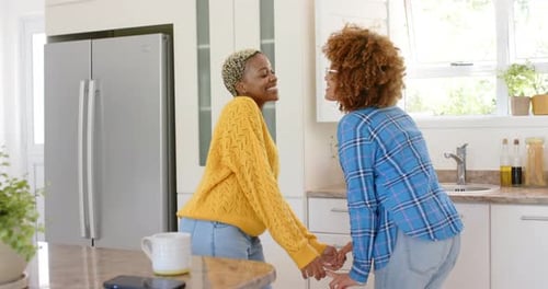 Affectionate Women Dancing Together in Bright Kitchen