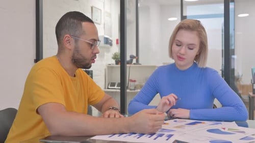 Team Discussing Charts and Graphs in Modern Office