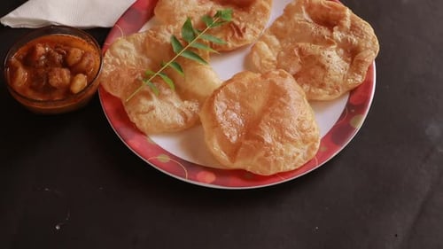 rotation Chole Bhature or Chick pea curry and Fried Puri served in terracotta crockery over black ba