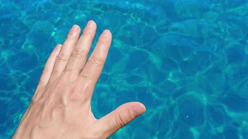 Hand Caressing Transparent Turquoise Water Surface