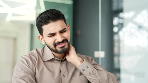 Man Massaging Neck in Painful Office