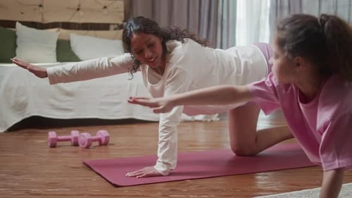 Woman and Girl Doing Yoga in Living Room